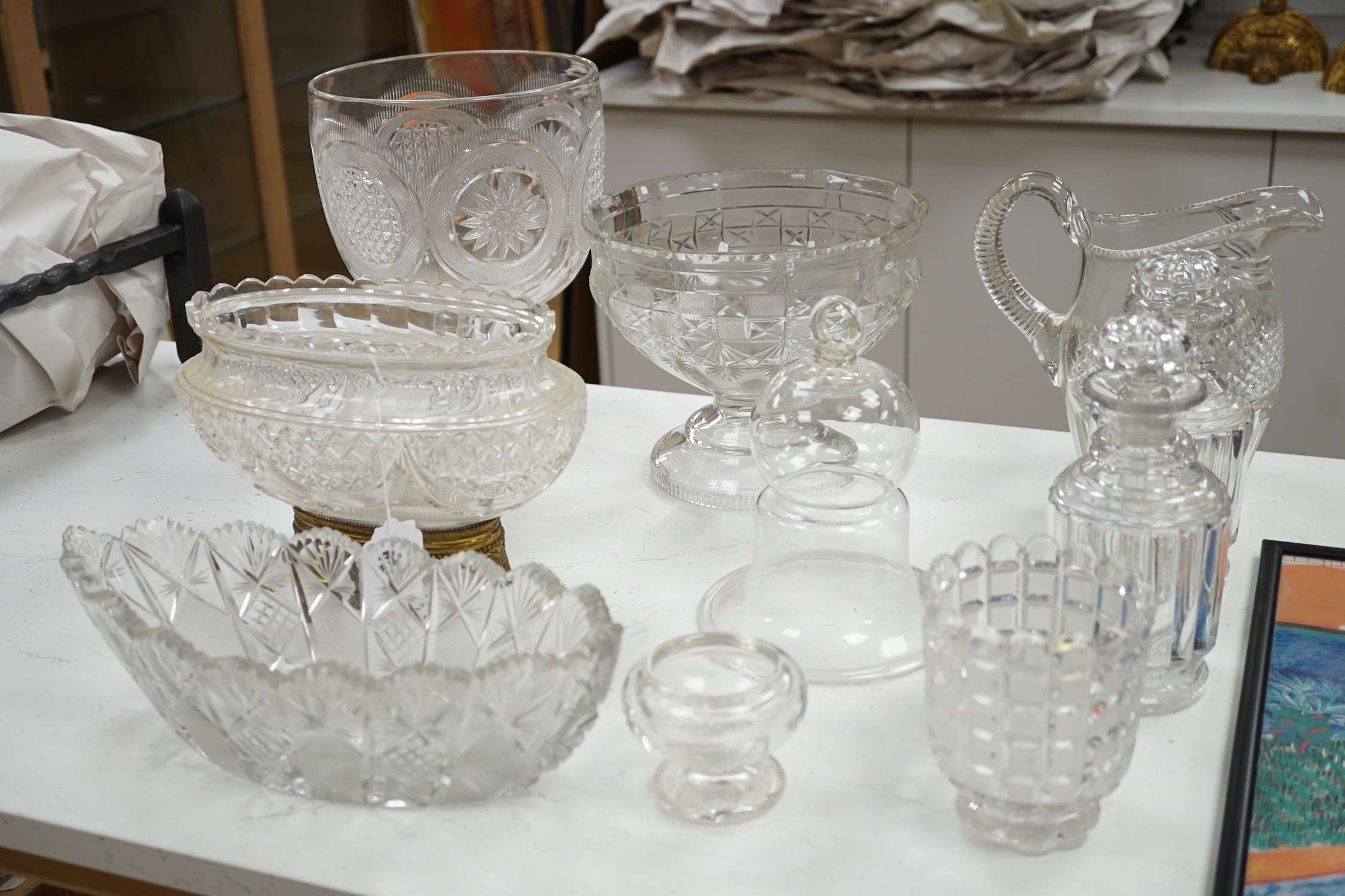 An early 20th century oval cut glass bowl on gilt metal stand, a pair of slice cut decanters and stoppers, a blown glass smoke bell two bowls and four other items of glassware, tallest 26 cm